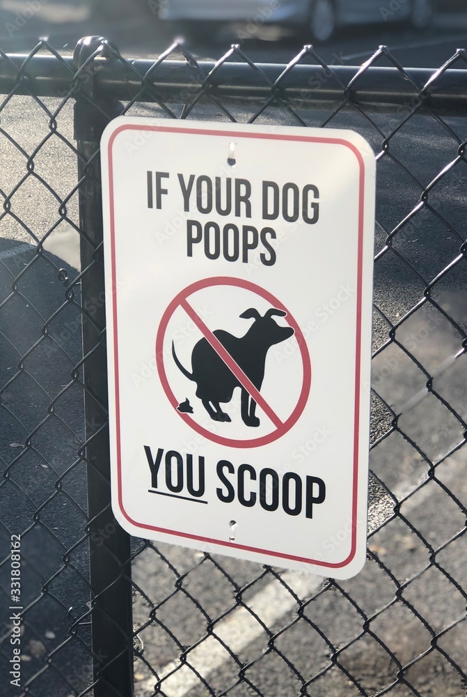 If your dog poops, you scoop - funny sign hanging on a fence near the sidewalk If your dog poops, you scoop - funny sign hanging on a fence near the sidewalk