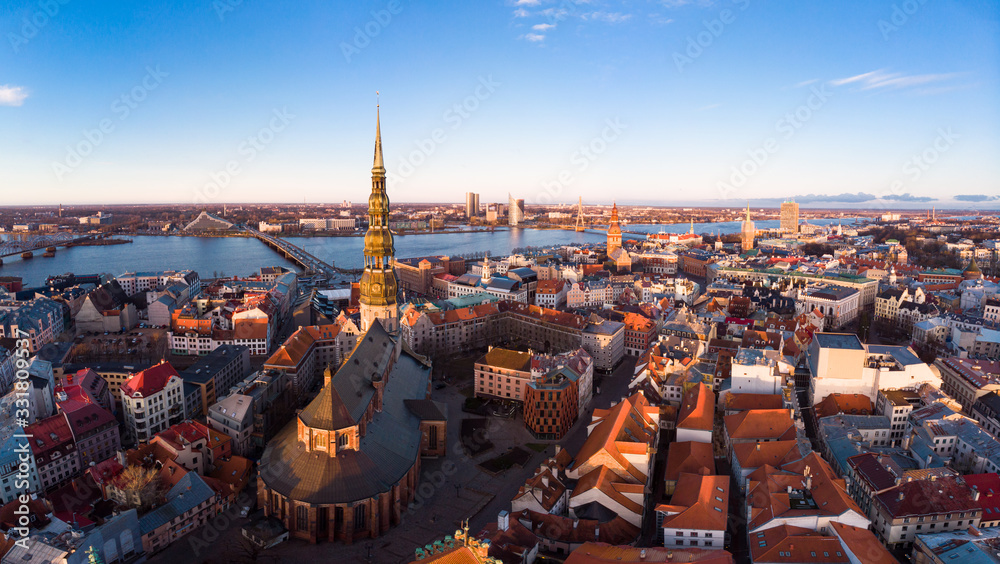 Aerial panoramic view to histirical center Riga, quay of river Daugava. Famous Landmark - st. Peter's Church's tower and City Dome Cathedral church, Old Town Monument. Latvia, Europe. shot from drone.