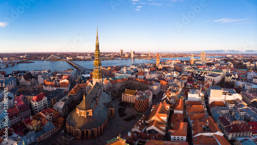 Aerial panoramic view to histirical center Riga, quay of river Daugava. Famous Landmark - st. Peter's Church's tower and City Dome Cathedral church, Old Town Monument. Latvia, Europe. shot from drone.