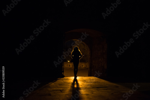 Silhouette of a girl who stands in front of a light source