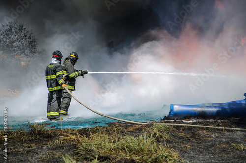 Two firefighters containing the flames