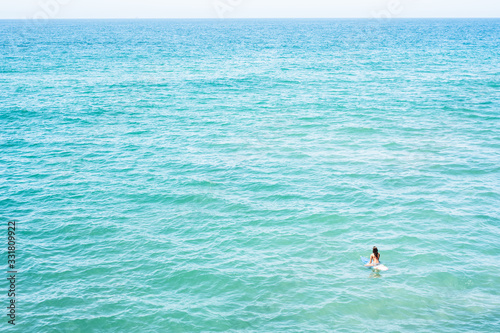 Girl surfer in the midlle of the ocean photo