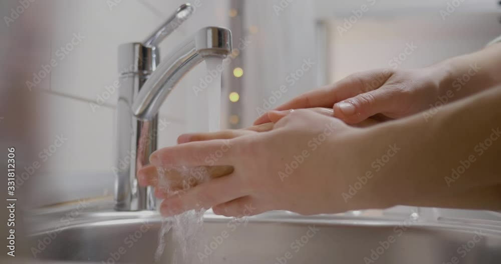 Mom helping her son how to proper wash his hands
