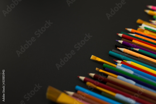 Coloured pencils on black background with copy space. Education, creativity, art.