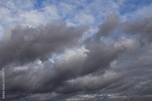 Cumulus fluffy white and dark grey storm clouds against blue sky background, heaven 