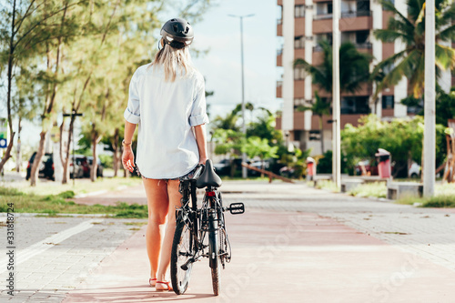 Young woman pulling her folding bicycle outdoors
