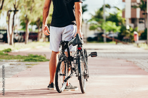 Young man pulling his folding bicycle outdoors