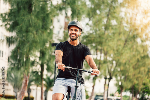 Portrait of young cyclist on his bicycle wearing helmet outdoors