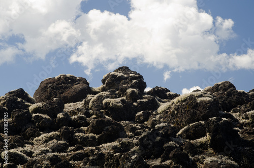 Field of solidified lava covered by lichens and clouds.