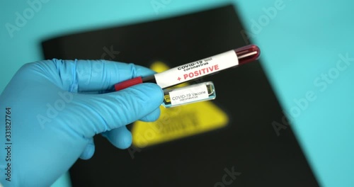 Doctor holds COVID 19 Coronavirus vaccine in his hand, infected blood sample in the sample tube, Vaccine and syringe injection It use for prevention, immunization and treatment from COVID-19