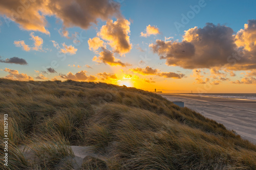The sand dunes of Oostende (Ostend in English) and Bredene at sunset with the skyline and pier of Ostend in the background, West Flanders, Belgium.