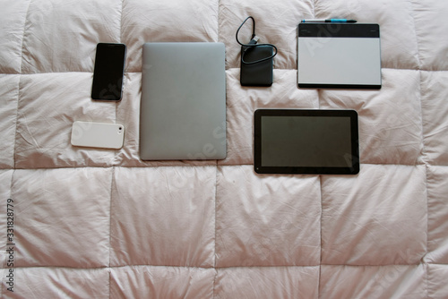 ordered devices on bed with space