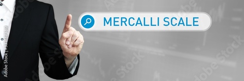 Mercalli Scale. Man in a suit points a finger at a search box. The word Mercalli Scale is in the search. Symbol for business, finance, statistics, analysis, economy photo