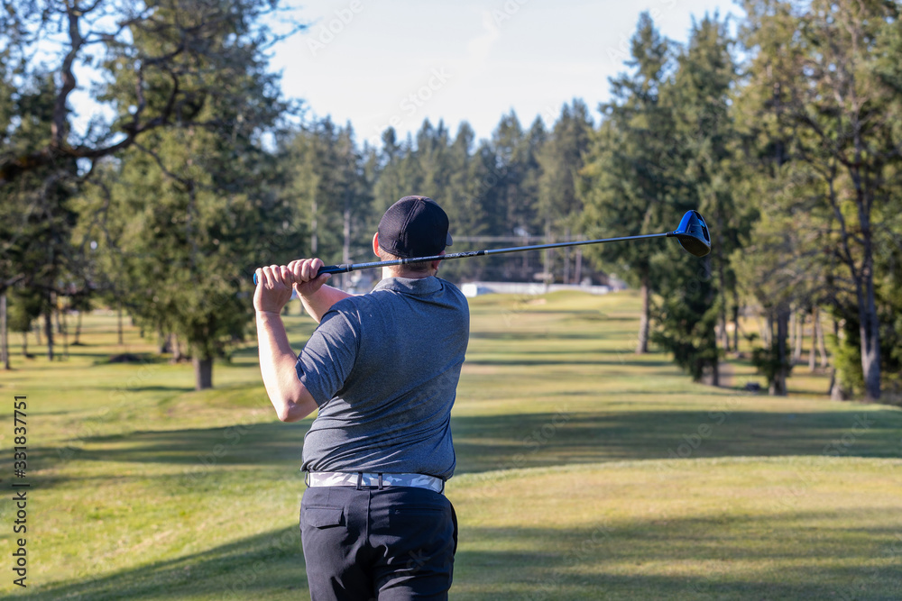 Golfer teeing off on a golf course Golfer teeing off on a golf course
