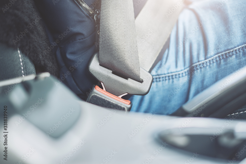 Fastens the car seat belt. Close the car seat belt while sitting in the car before driving, a male driver’s shot fastens the seat