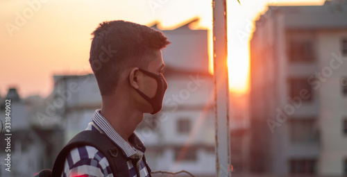Coronavirus infected ill Italian young man feeling sick, wearing protective mask against transmissible infectious diseases and as protection against the flu in public and transportation.