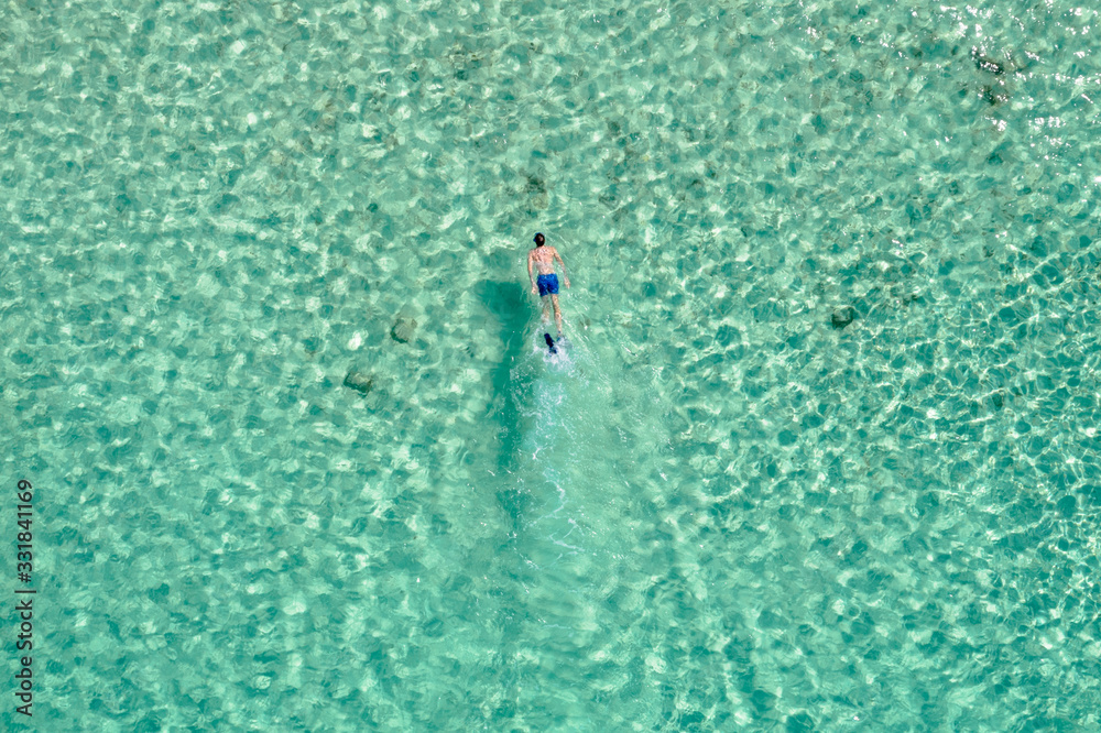Overhead drone shot of man swimming in ocean