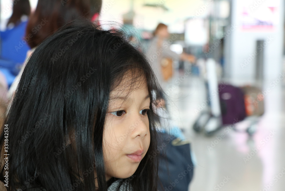 Face of Asian cute girl at the airport , she is waiting international flight  with her family 