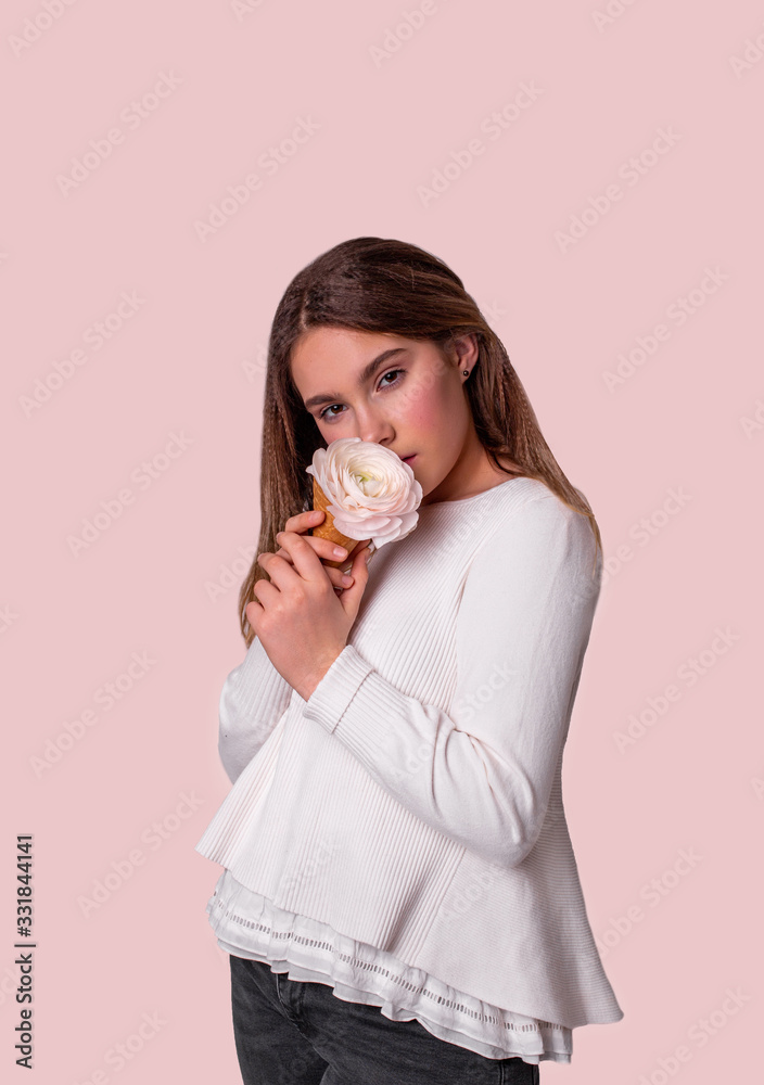 vertical portrait of a cute girl with ice cream from flowers on a light pink background vertical portrait of a cute girl with ice cream from flowers on a light pink background