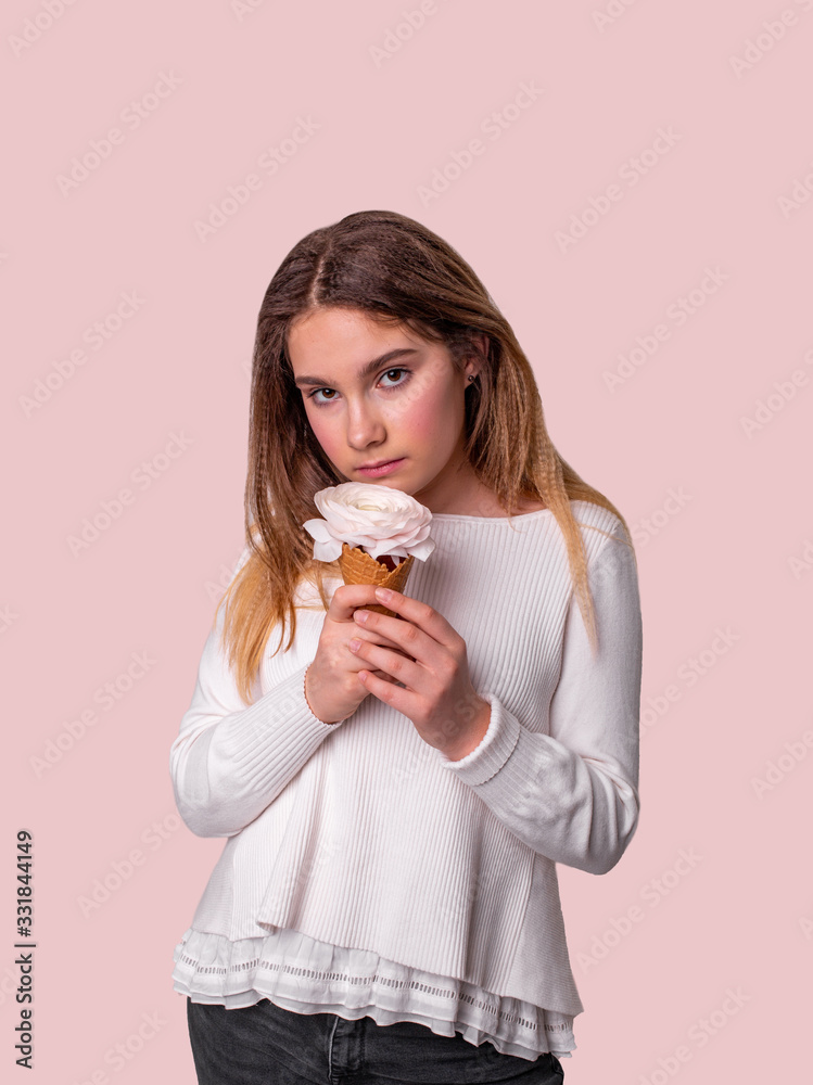 vertical portrait of a pretty girl with flowers ice cream on a light pink background vertical portrait of a pretty girl with flowers ice cream on a light pink background