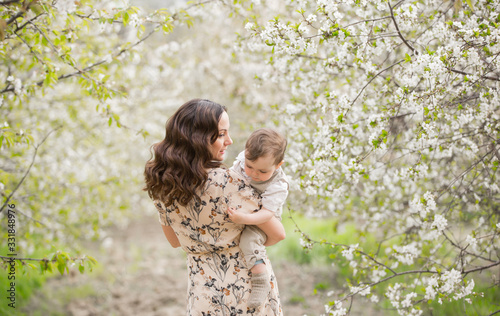 Family for a walk in the blooming cherry garden