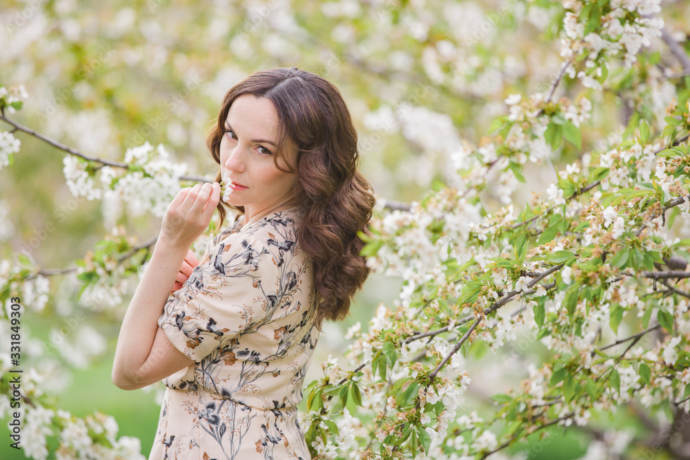 Beautiful young girl in a flowered garden