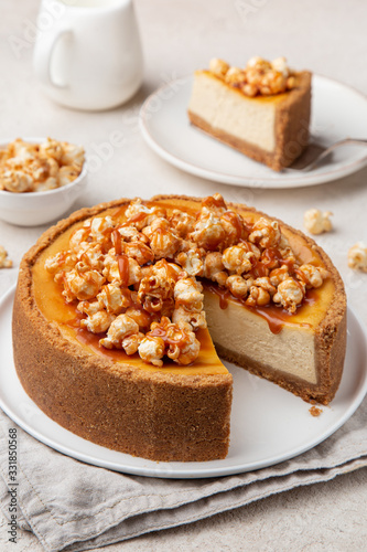 delicious caramel cheesecake with popcorn and salted caramel sauce on white background
