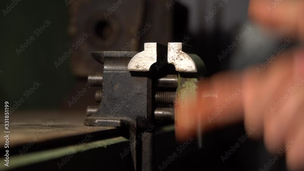 The arm pushes small engineering vice.That is fixed on the table The arm pushes small engineering vice.That is fixed on the table