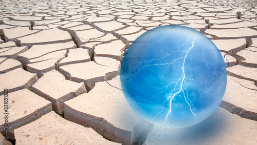 Global Warming Concept - Thunder and lighning inside glass sphere on Dry Soil