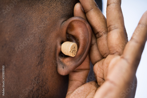 Man Wearing Hearing Aid And Listening For A Quiet Sound