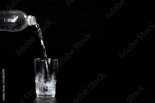 pouring water into a glass on a dark background