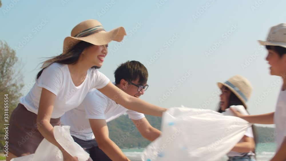 Asian young happy family activists collecting plastic waste on beach. Asia volunteers help to keep nature clean up and pick up garbage. Concept about environmental pollution problems. 4k Slow motion.