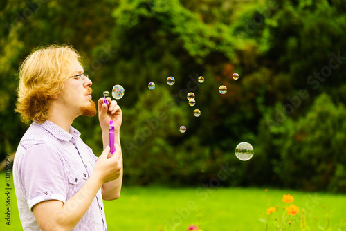 Man blowing soap bubbles outdoor