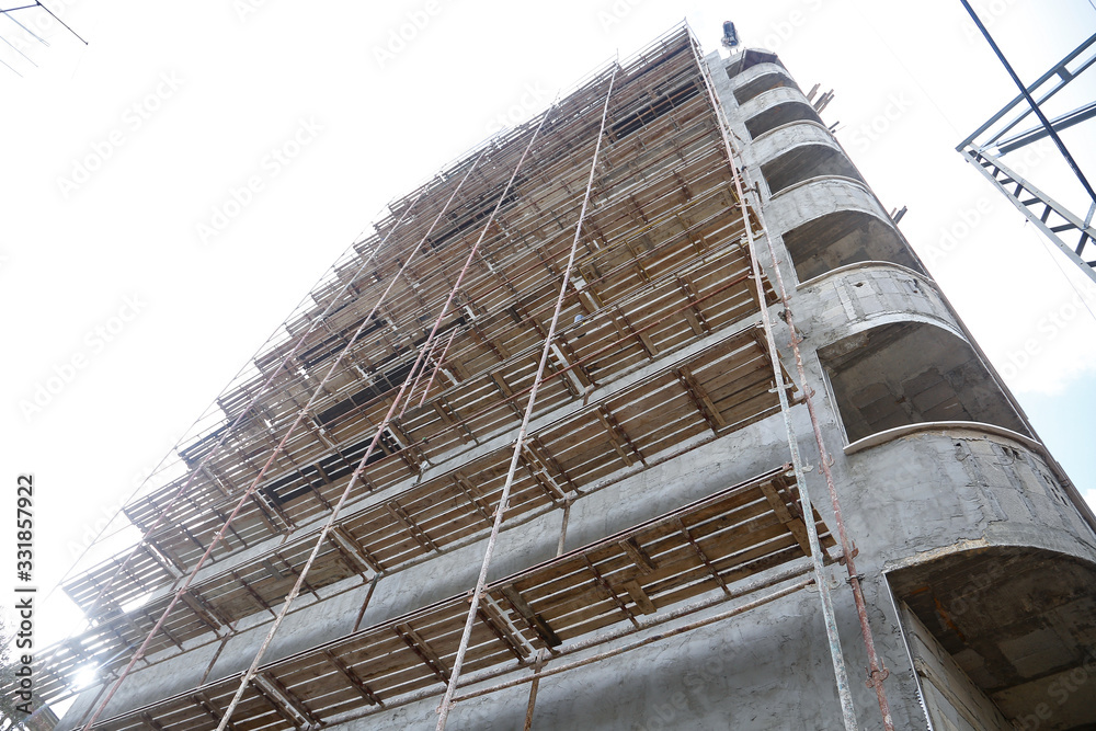 Modern building is under construction, metal scaffolding 