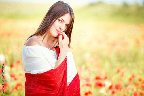 young beautiful woman walking through a poppy field