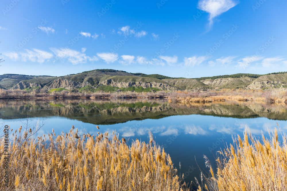 Laguna Picon de Los Conejos con reflejo de las montañas en Velilla de San Antonio