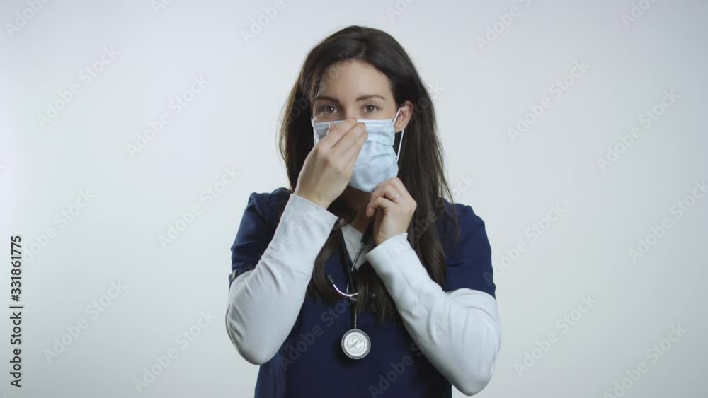 Nurse holds up mask and demonstrates how to put it on properly Nurse holds up mask and demonstrates how to put it on properly