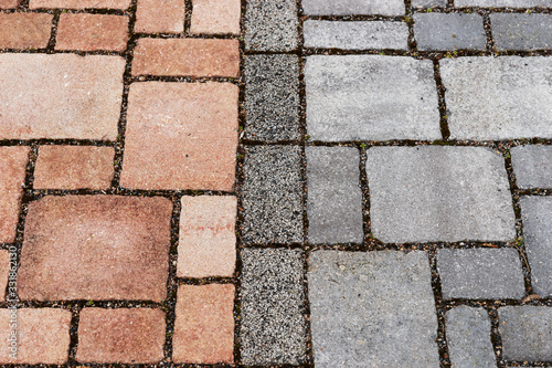 Red and gray brick paving stones on a sidewalk. Separation of bike and footpath