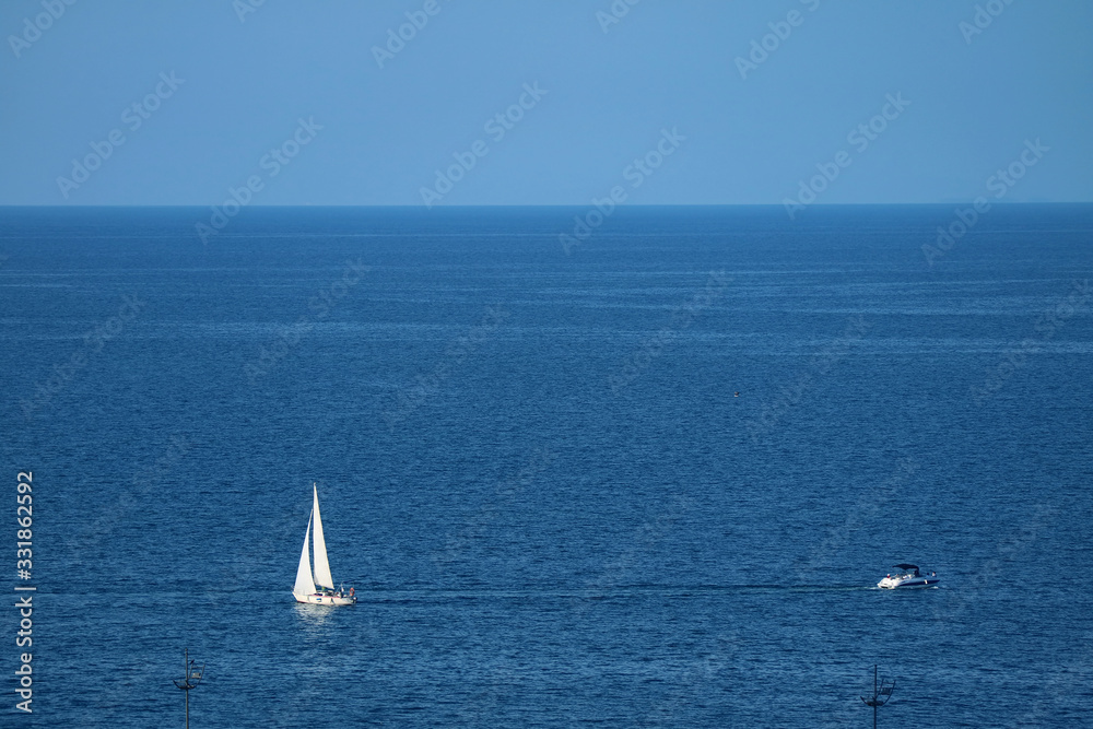 Aerial view of white sailboats on the blue sea with copy space