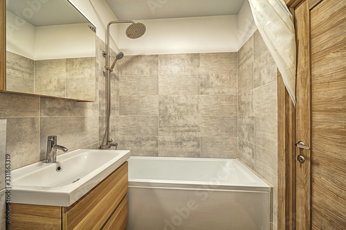 Small beige tile bathroom with bath tube