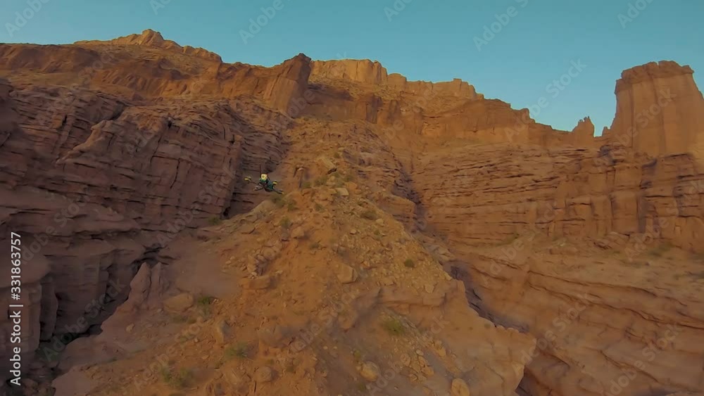 Two cinematic FPV racing drones chasing each other through a canyon near Fisher Tower, Utah, racing drone, stunt, acrobatic Two cinematic FPV racing drones chasing each other through a canyon near Fisher Tower, Utah, racing drone, stunt, acrobatic