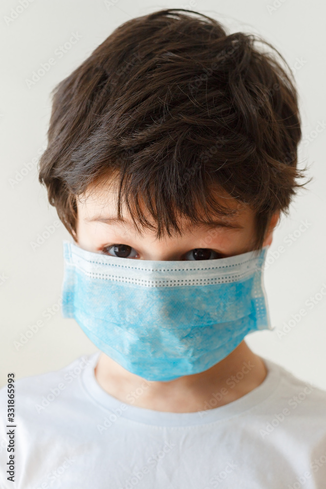Cute little asian  boy wearing health mask, looking up, isolated over white background