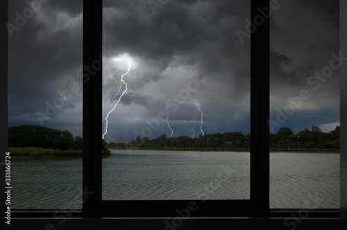 Scared lightning strikes over the forest and river