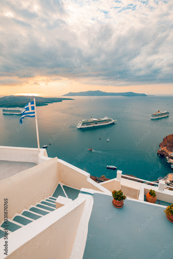 Amazing evening view of Fira, caldera, volcano of Santorini, Greece with cruise ships at sunset. Cloudy dramatic sky. Amazing evening view of Fira, caldera, volcano of Santorini, Greece with cruise ships at sunset. Cloudy dramatic sky.