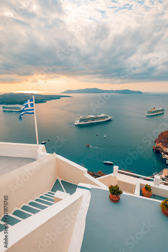 Amazing evening view of Fira, caldera, volcano of Santorini, Greece with cruise ships at sunset. Cloudy dramatic sky. © icemanphotos