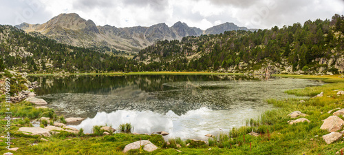 Panoramic view of Lake Pessons where the clouds are reflected in its calm waters. Grau Roig, Soldeu, Andorra photo