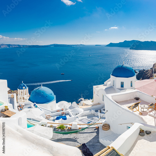Amazing summer landscape, luxury vacation. Oia town on Santorini island, Greece. Traditional and famous houses and churches with blue domes over the Caldera, Aegean sea