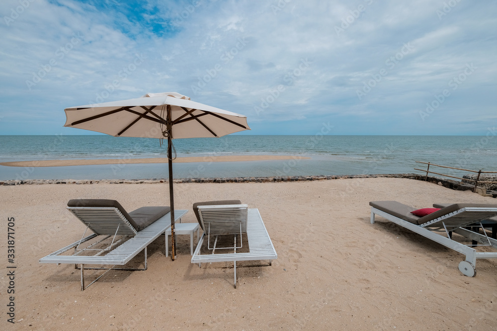 chairs and umbrella on tropical beach, vacation time after hard work chairs and umbrella on tropical beach, vacation time after hard work