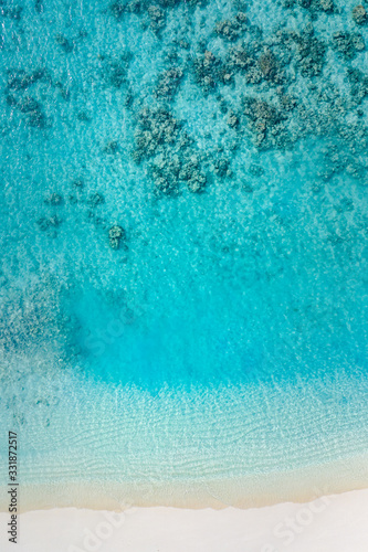 Sand beach aerial, top view of a beautiful sand coral beach aerial shot with the blue waves rolling into the shore. Tranquility and meditation background
