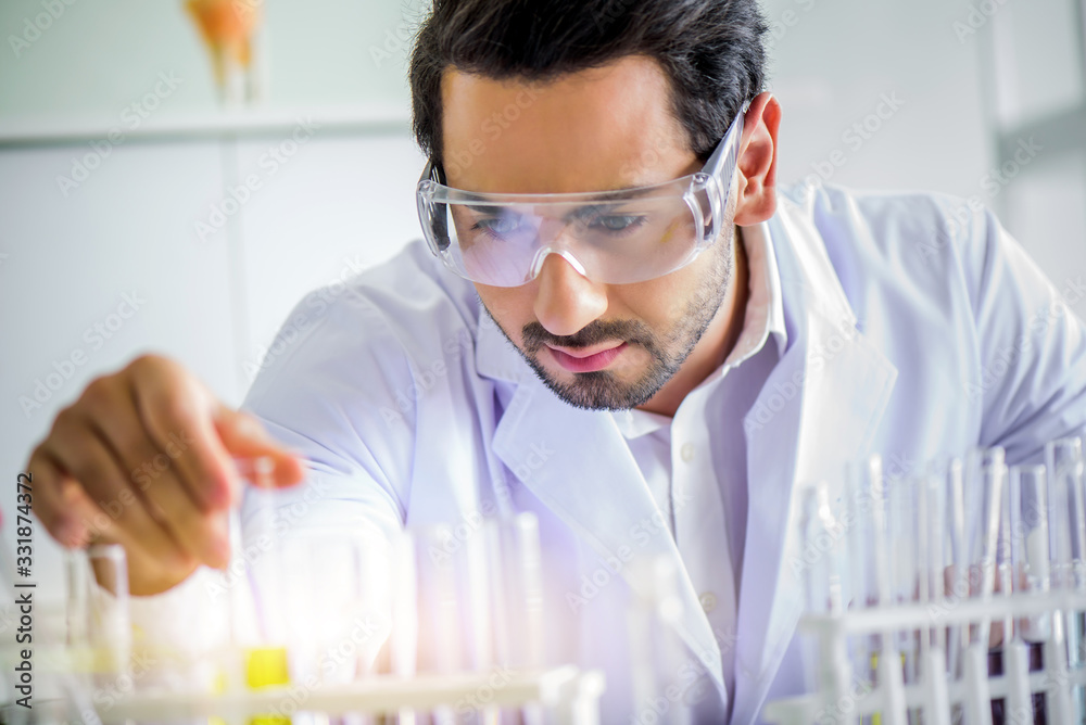 Attractive happiness scientist man lab technician assistant analyzing sample in test tube at laboratory. Medical, pharmaceutical and scientific research and development concept. Attractive happiness scientist man lab technician assistant analyzing sample in test tube at laboratory. Medical, pharmaceutical and scientific research and development concept.